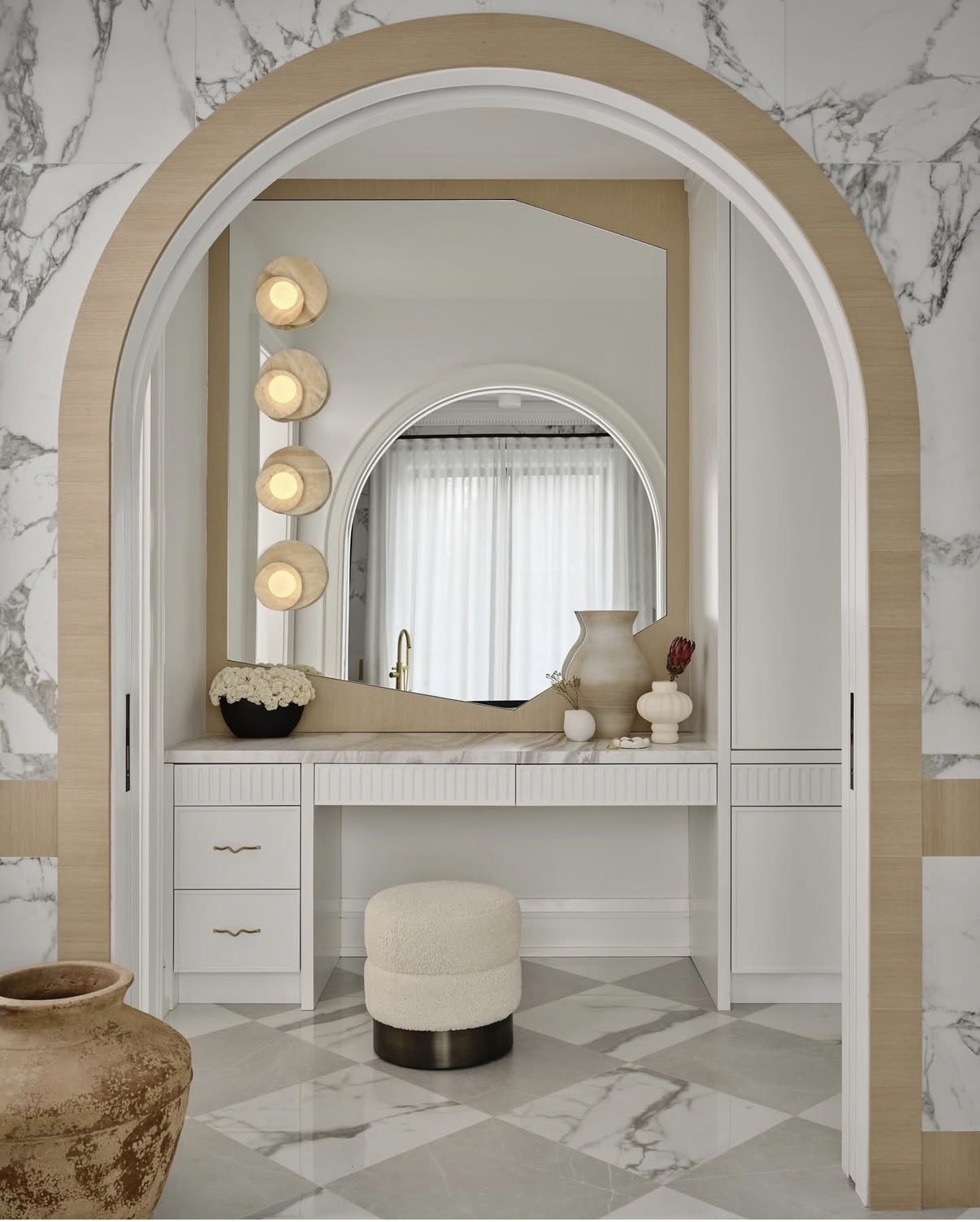 Marble-arched vanity with fluted millwork